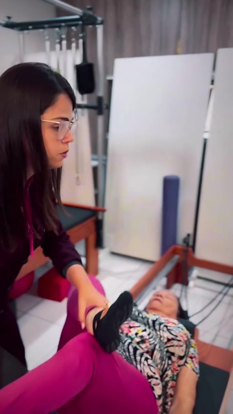 Fisioterapeuta atendendo paciente em aparelho de Pilates